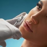 cosmetologist-using-syringe-correct-female-face